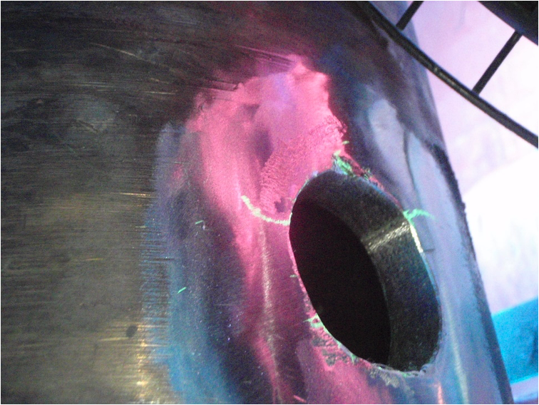 Figure 2. Fluorescent Liquid Penetrant Inspection (FLPI) showing fatigue cracks radiating off of the weldolet to 10-inch process line connection.